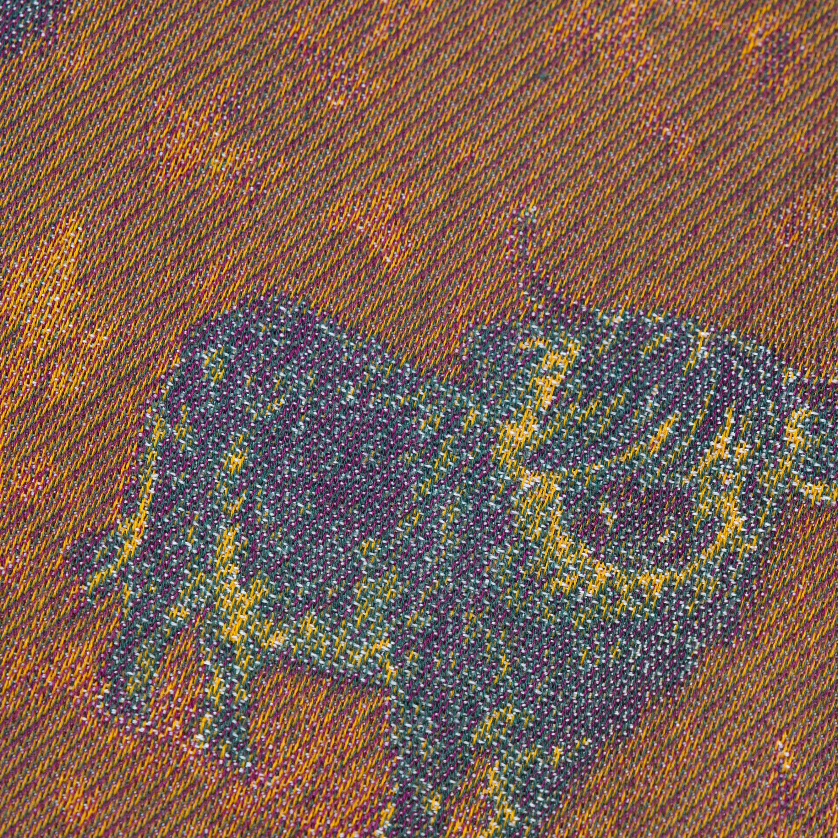 A close-up of a woven fabric pattern featuring a dark bull silhouette over a warm brown and orange textured background.
