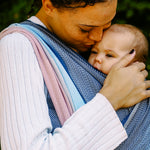 Lisca Opal Woven Wrap by Didymos, parent cuddling a baby in a front carry