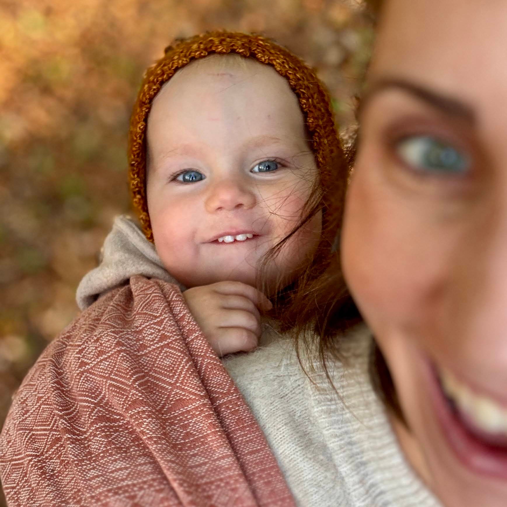 Prima Rosewood Woven Wrap by Didymos, baby smiling from a front carry outdoors