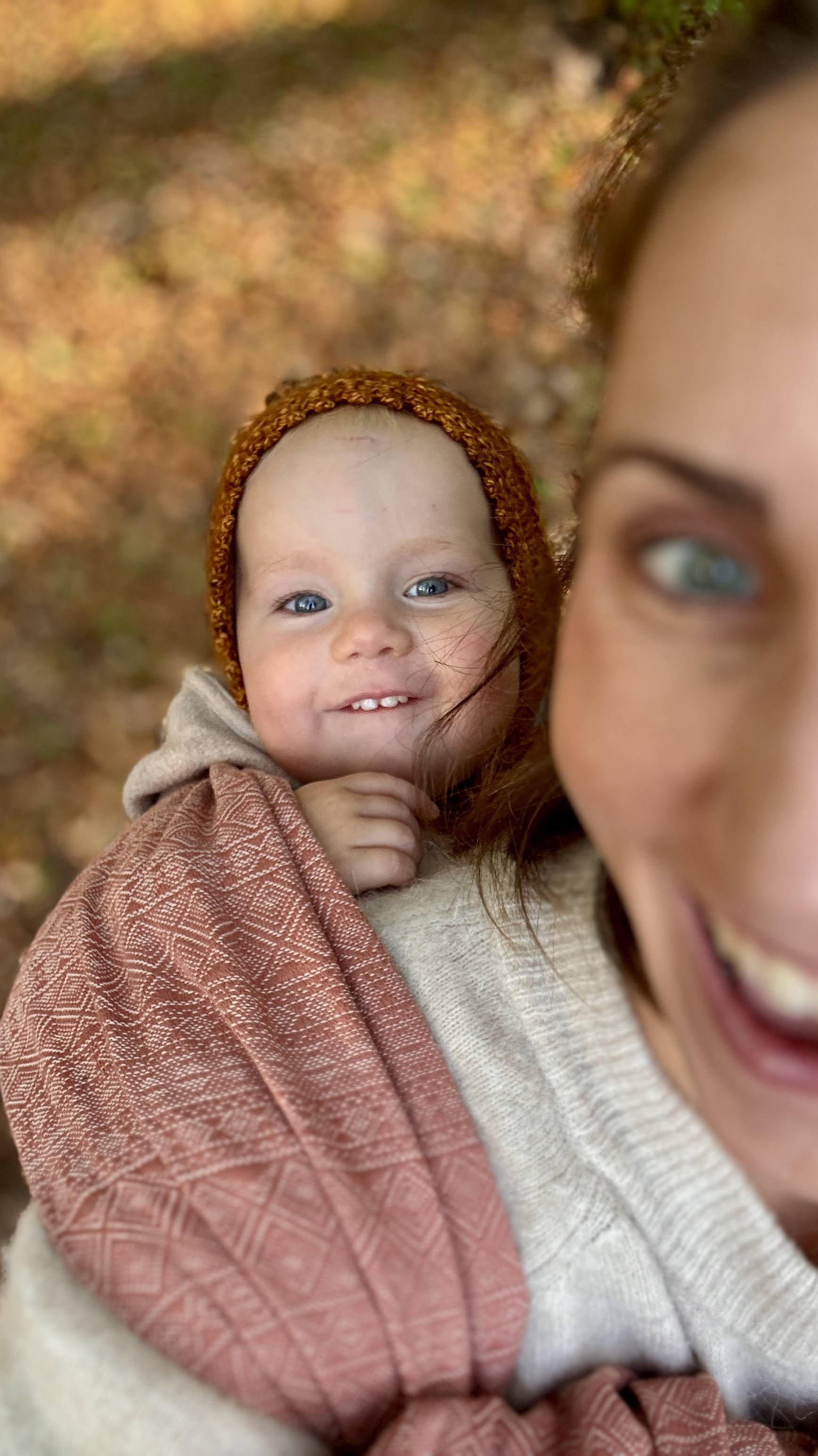 Prima Rosewood Woven Wrap by Didymos, baby smiling from a front carry outdoors