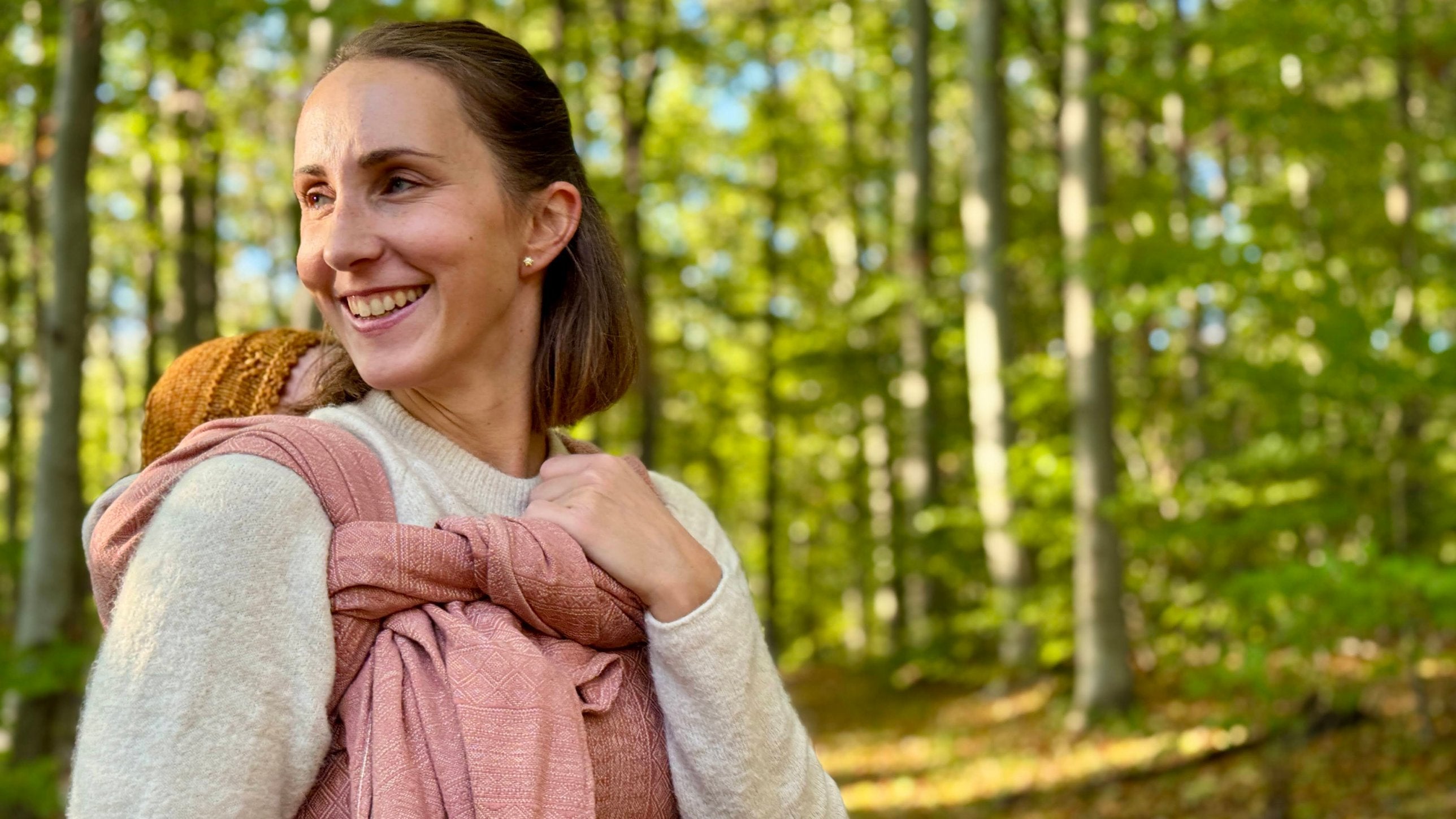 Prima Rosewood Woven Wrap by Didymos, parent carrying a baby on her back in the woods