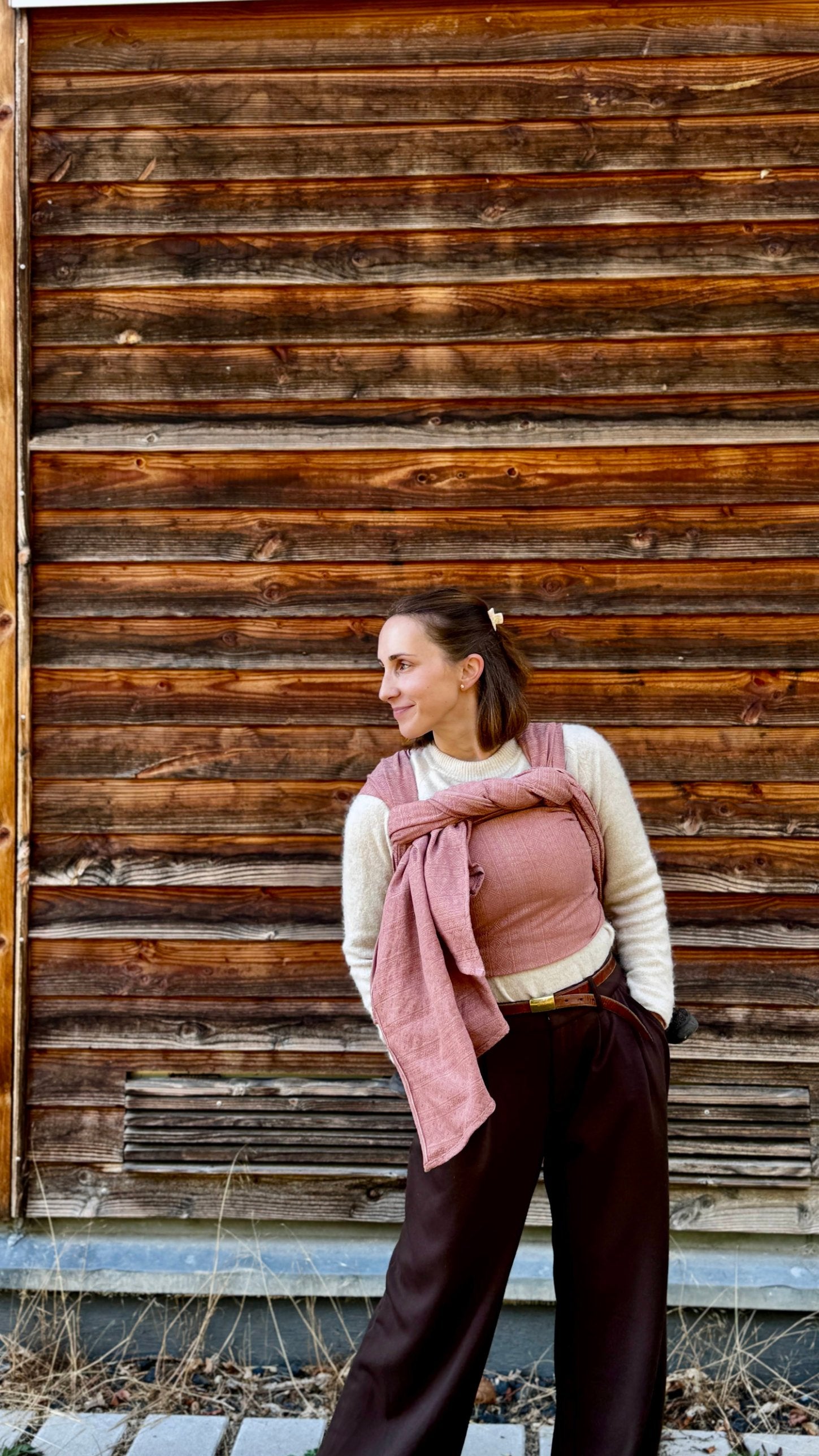 Prima Rosewood Woven Wrap by Didymos, full length front carry against a wooden wall