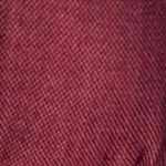 Person wearing a maroon baby carrier against a plain background