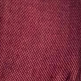 Person wearing a maroon baby carrier against a plain background